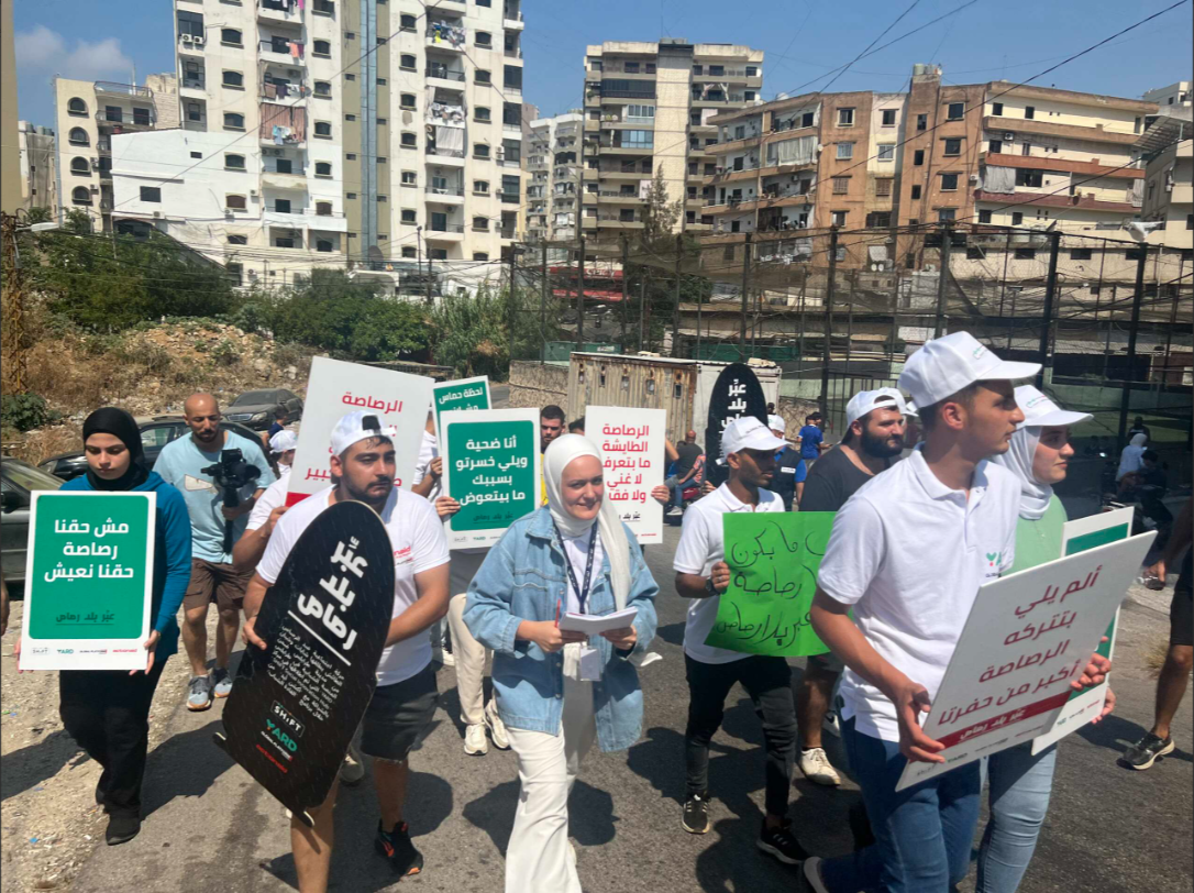 YARD youth marching with advocacy placards through a Tripoli street.